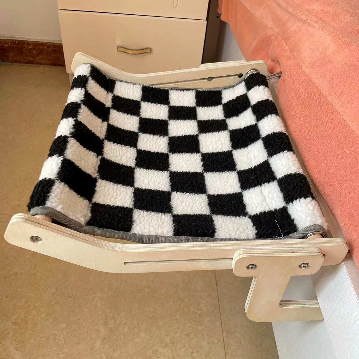 Detail van de haakbevestiging van de Lumi Perch aan een meubelrand